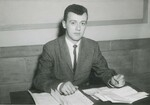 Suffolk University Professor John O'Callaghan (CAS) seated behind desk, photograph, circa 1950s