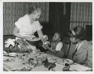 Unidentified woman and clients eating turkey