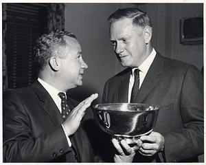 Two unidentified men conversing while holding silver bowl