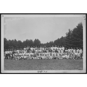 Group portrait of summer camp in field in front of trees