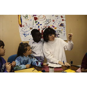 Woman helping children with an art project