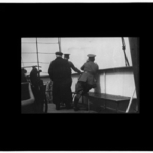 Three men looking off the side of the ship