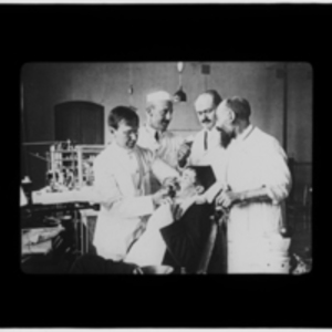 Doctors performing dental work on a patient