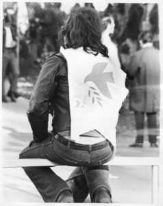Suffolk University student protester wearing a vest depicting a peace dove