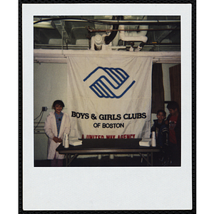 Sixteen boys and girls posing with the Boys and Girls Clubs of Boston banner during an event at the Chelsea Clubhouse