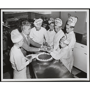 Members of the Tom Pappas Chefs' Club share pie with a staff person in the Shearton Plaza Hotel testing kitchen