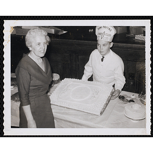 A member of the Tom Pappas Chefs' Club and Barbara Sherman Burger pose with a decorated cake