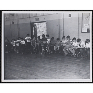 A Group of boys sitting around a room and working on an arts and crafts project