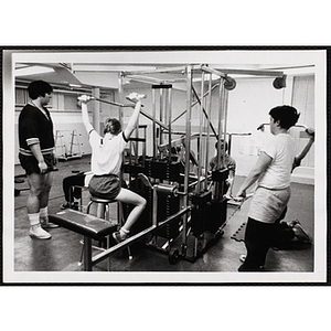 A group of youth lift weights inside a gymnasium