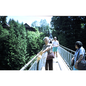 Woman stands on the Capilano Suspension Bridge in British Columbia's temperate rain forest