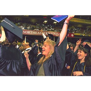 Graduates cheer after receiving their degrees during commencement