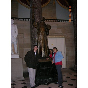 Three Torch Scholars pose in front of a statue of Junipero Serra in Washington D.C