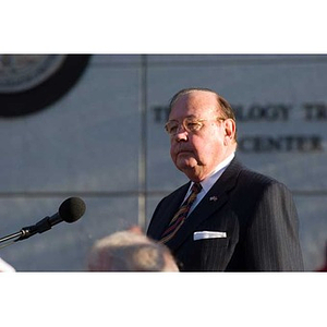 Richard Egan stands at the microphone at the Veterans Memorial dedication ceremony