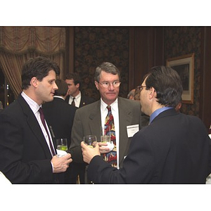 Three men with drinks at the gala dinner for John Hatsopoulos