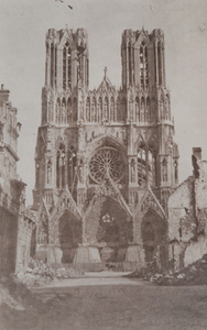 Exterior view of the front of a cathedral showing damage, Reims