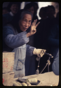 Old woman holding up four fingers in communicating