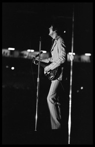 Paul McCartney (the Beatles) playing bass and singing in concert at D.C. Stadium: full-length portrait