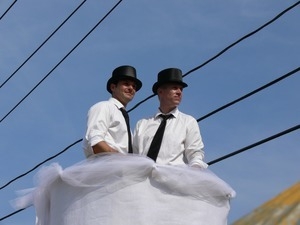 Parade marchers dressed like grooms in an oversize wedding cake : Provincetown Carnival parade