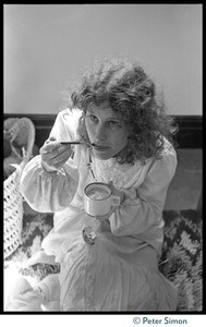 Cathy Brown (Usha), seated on the floor, eating