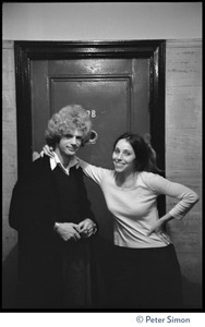 Unidentified man and woman, back stage, standing in front of a door