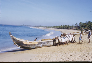 Villagers launching a canoe