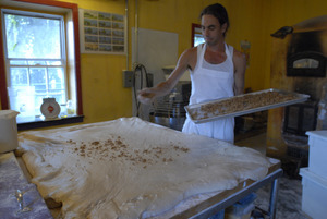 Hungry Ghost Bread: owner and baker Jonathan C. Stevens spreading filling dough for cinnamon rolls