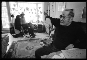 W. Eugene Smith, seated at a desk in his home