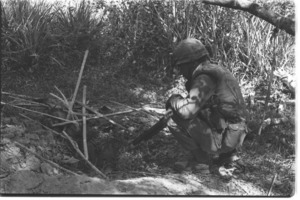 U.S. soldiers of 1st Infantry Division searching Vietcong hole; Hau Nghia.