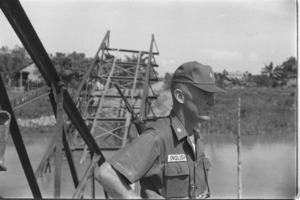 Clear and hold operation. U.S. officers inspecting bridge sabotaged by Vietcong; Mekong Delta.