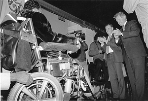 Mayor Raymond L. Flynn, Senator Edward M. Kennedy applauding an unidentified man in a wheelchair