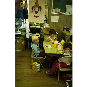 Young children at a table eating a snack