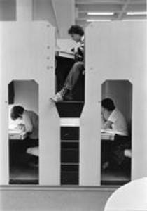 Three students in Sawyer Library's monkey carrel