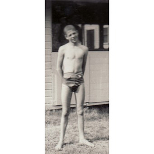 A boy in swimming trunks poses for the camera at Breezy Meadows Camp