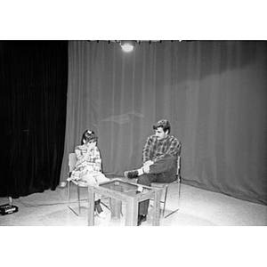 Man and a teenage girl on the set of Villa Victoria's Channel 6 public access television station.