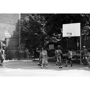 Kids playing basketball in a playground in the Villa Victoria neighborhood.