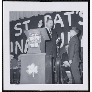Donald M. DeHart presents an oath to a boy at a Boys' Club of Boston St. Patrick's Day inaugural ball and exercises event