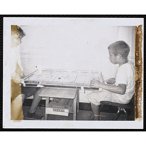 Two boys play a Bobby Hull brand tabletop hockey game