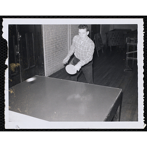 A teenage boy plays table tennis