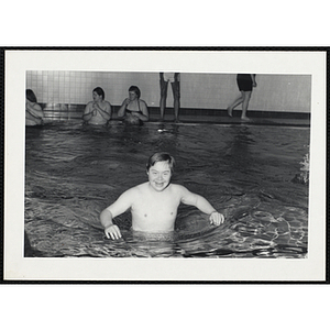 A teenage boy wades in a natorium pool