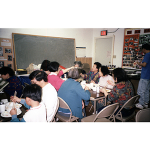 Members sit eating dinner during an unnamed Chinese Progressive Association event