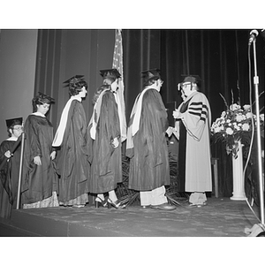 Raymond Robinson shakes hands with graduates at the 1975 fall commencement ceremony