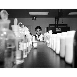 Behind rows of bottles, a College of Criminal Justice student works in a forensic science laboratory