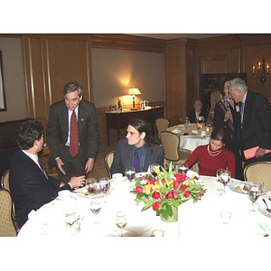 President Richard Freeland, standing, greets guests at the gala dinner for John Hatsopoulos