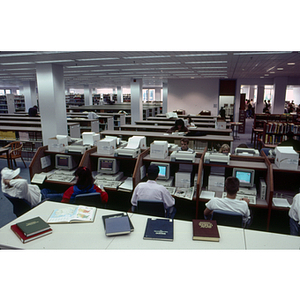 Students using computers and books in Snell Library