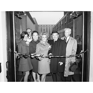 Several people stand together to cut the ribbon at the dedication and cornerstone laying ceremony for Dockser Hall