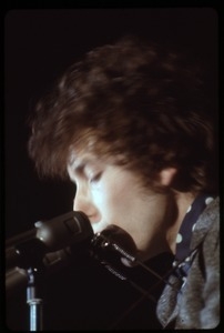 Bob Dylan performing on stage, playing harmonica