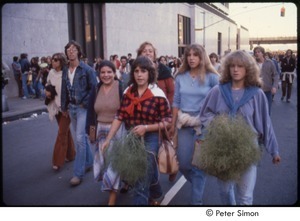 MUSE concert and rally: women holding plants, walking down street