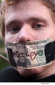 Occupy Wall Street: close-up of demonstrator with a twenty dollar bill taped over his mouth