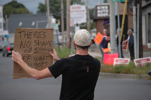 Protest against a pornographic video store in Northampton: counter-protester holding sign reading 'Theres no shame of showing off what you got!'