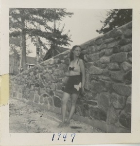 Bernice Kahn posing in her bathing suit against a stone wall
